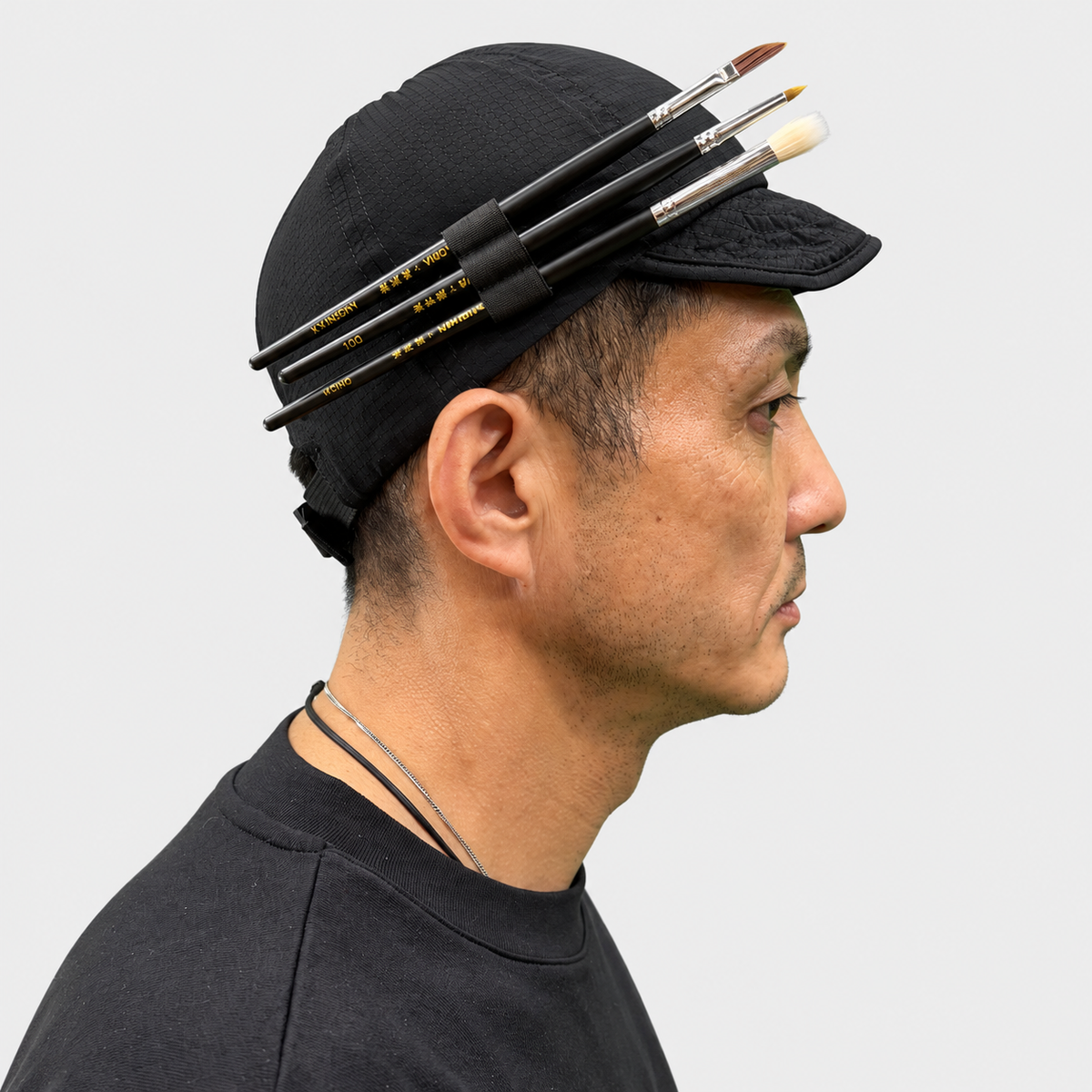 BOWABOWA WORK CAP ブラックの着用例、右側面。サイドホルダーに筆3本を差した状態。