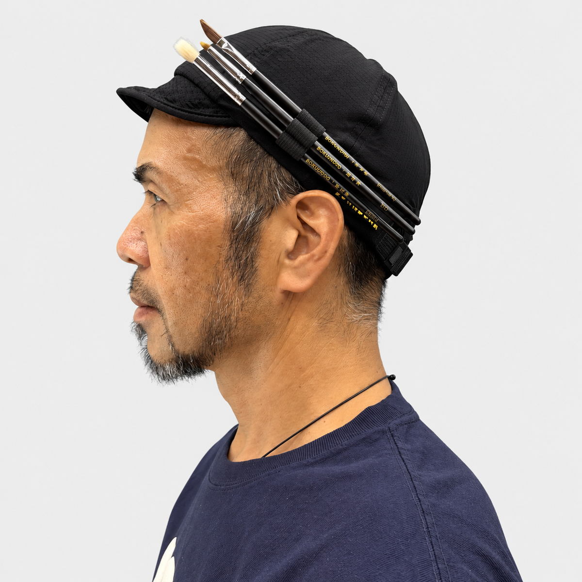BOWABOWA WORK CAP ブラックの着用例、左側面。筆3本をサイドホルダーに差した状態。